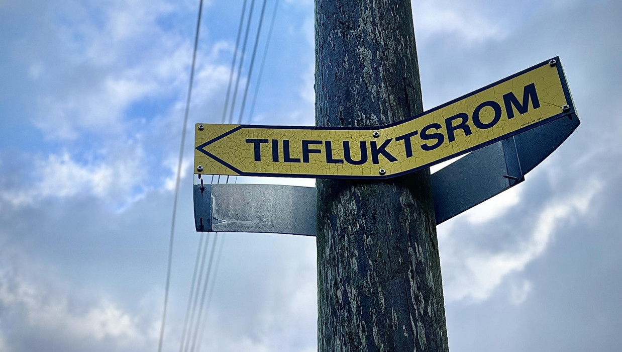 skilt på stolpe: tilfluktsrom